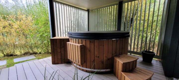 Badtunna i trä med lock och tekniklåda på en överbyggd terrass